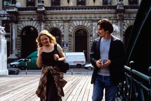 Young couple walking beside a Parisian building in a street scene